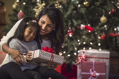 mother and daughter opening presents on Christmas